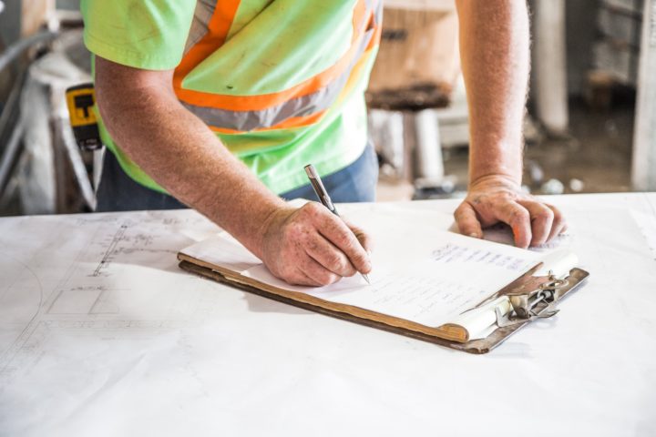 construction worker working on paperwork on a clipboard
