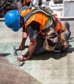 construction worker hammers in a nail