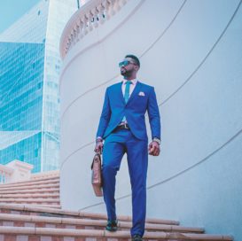 stylish black businessman walks down steps outside modern building