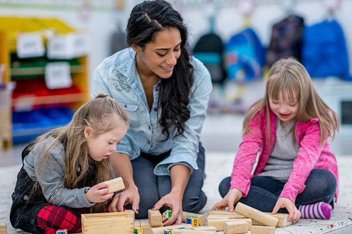 special education teachers plays blocks with two students