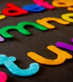 colorful felt cutout letters on a black felt board