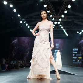 fashion model wearing floor length dress at the front of the catwalk