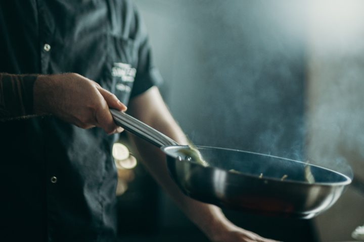 Culinary Arts chef sautes food in a skillet in a professional kitchen