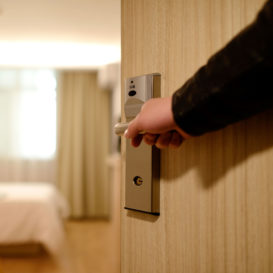 doorman opens hotel room door for guest