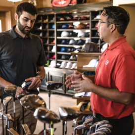 salesman trying to sell golf clubs to customer