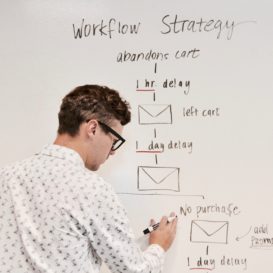marketing assistant writes ideas on whiteboard